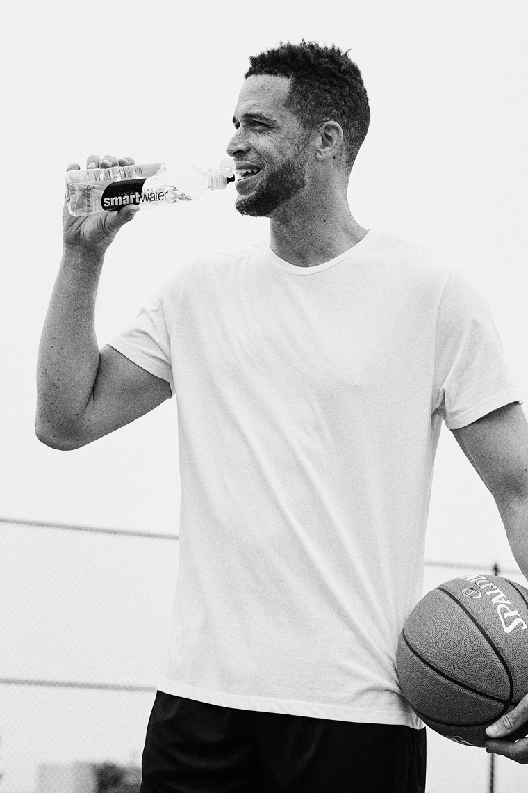 Man drinking Smartwater after playing basketball black and white