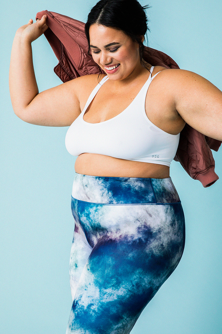Portrait of model in activewear smiling on blue background