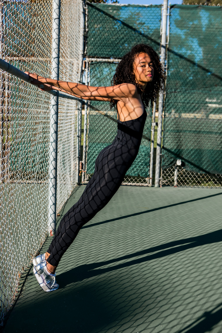 Woman in black catsuit on tennis court