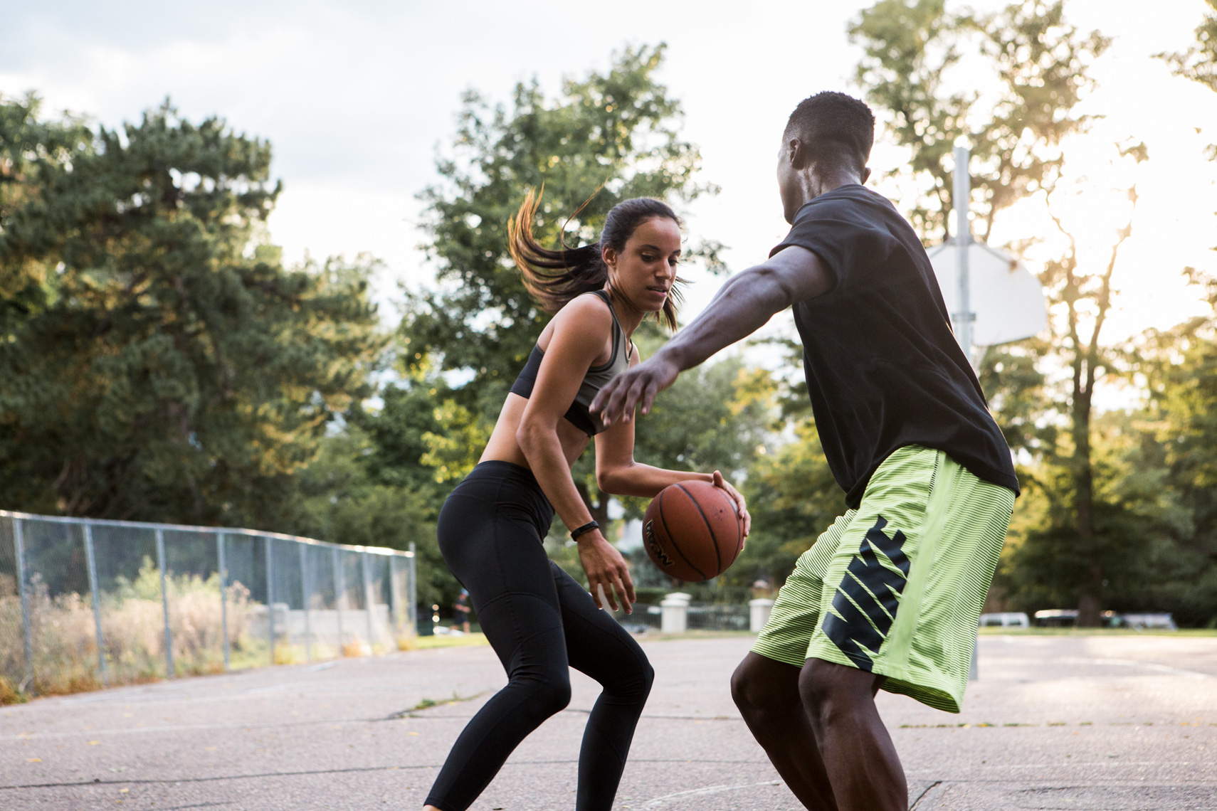 Man and woman playing basketball outdoors