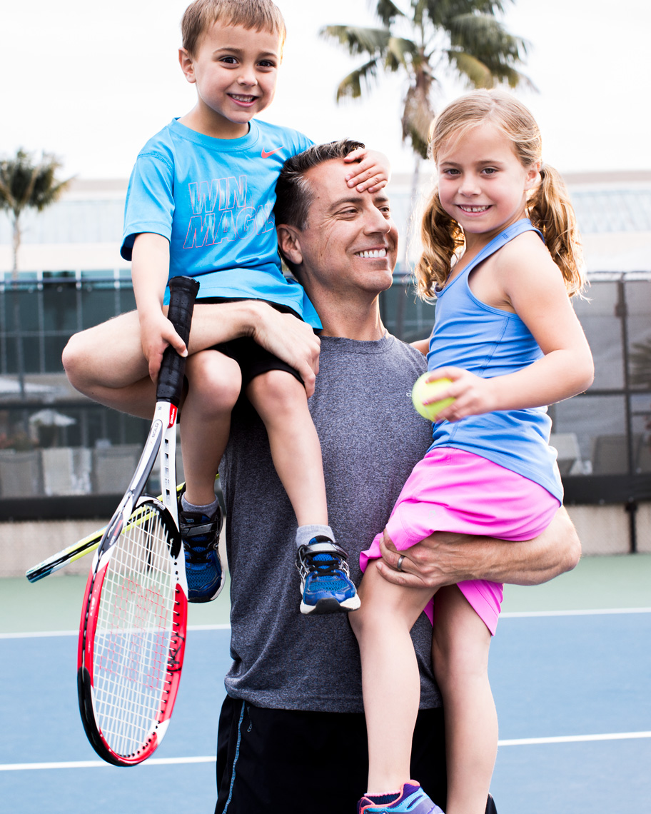 Dad and two children playing tennis