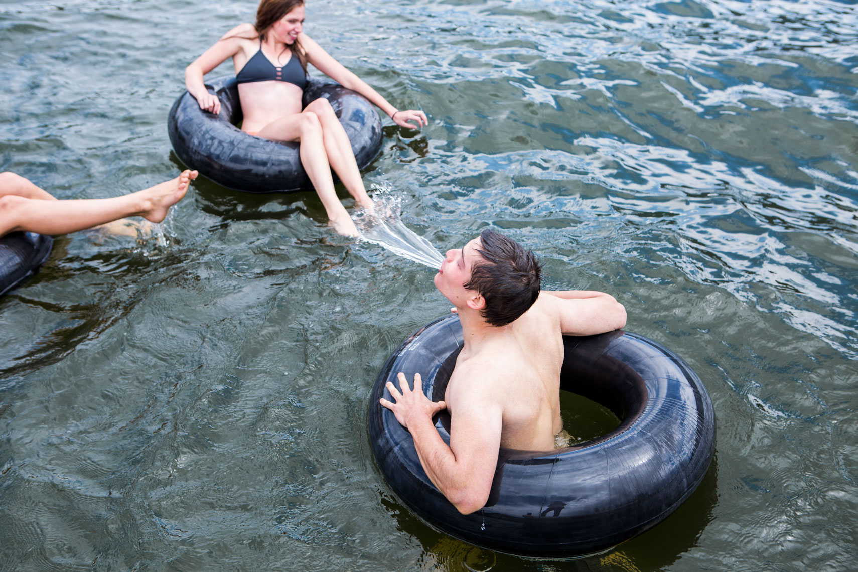 Friends playing in a lake in inner tubes 