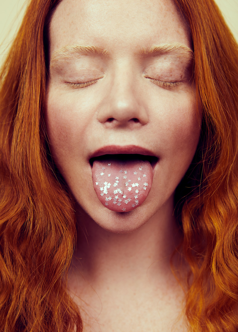 Beauty portrait of woman with tongue out and stars on tongue